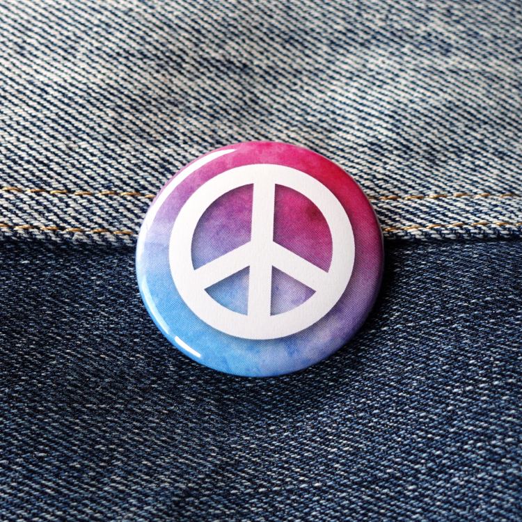 Ansteckbutton Peacezeichen auf Farbwolke auf Jeans